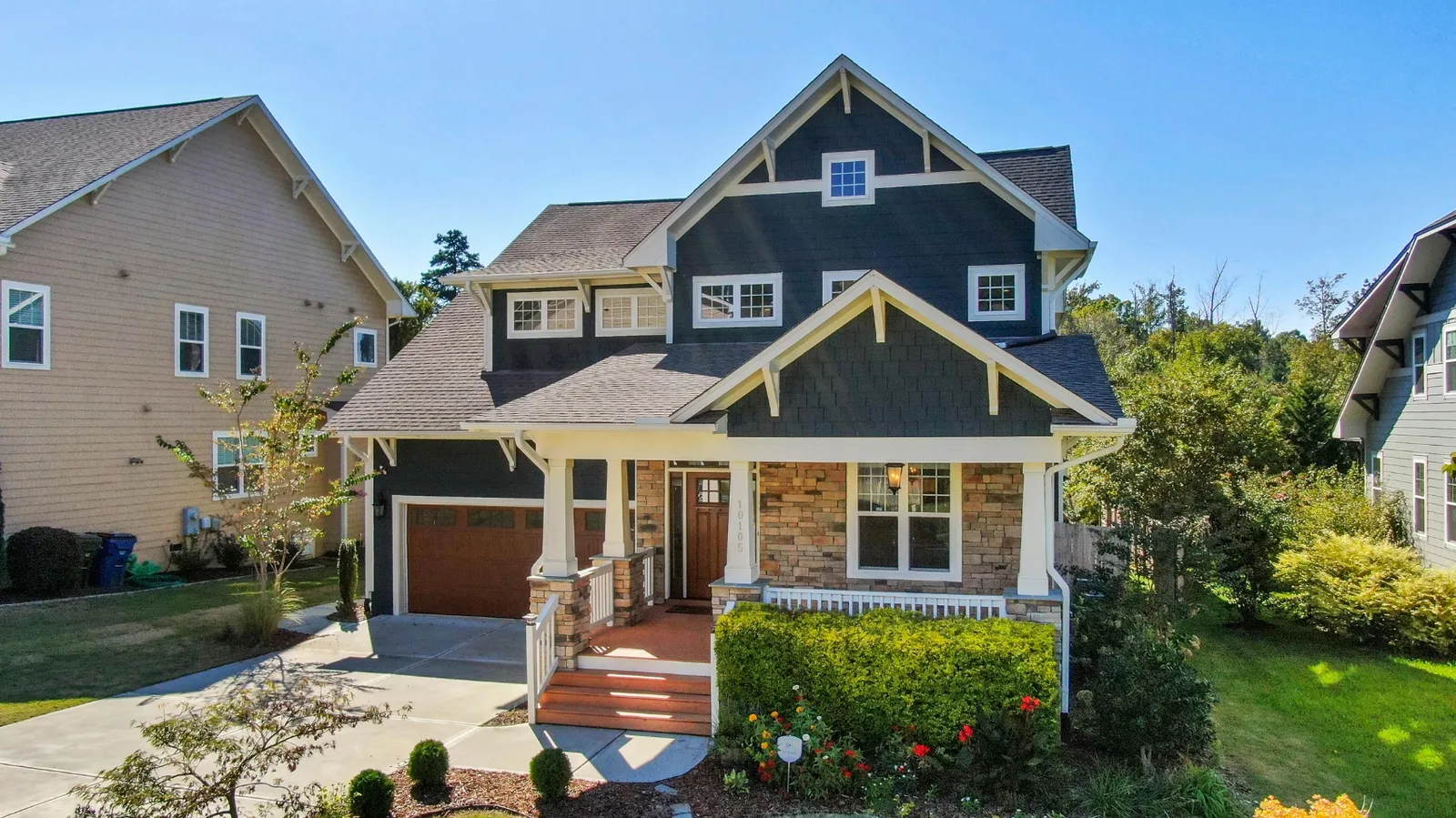 Blue two-story house with a gray shingle roof and a covered front porch